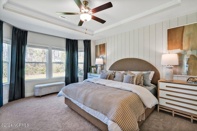 bedroom with carpet flooring, a tray ceiling, and ceiling fan