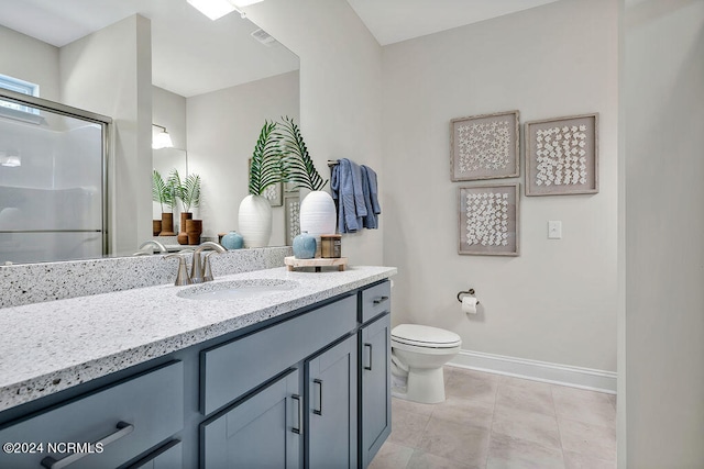 bathroom with tile patterned flooring, vanity, toilet, and walk in shower