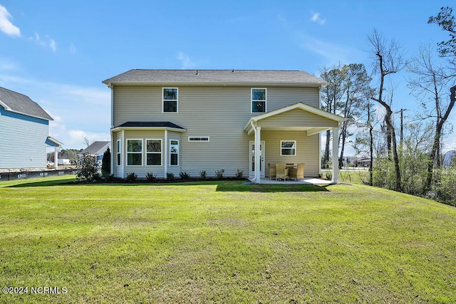 back of property with a yard and a patio area