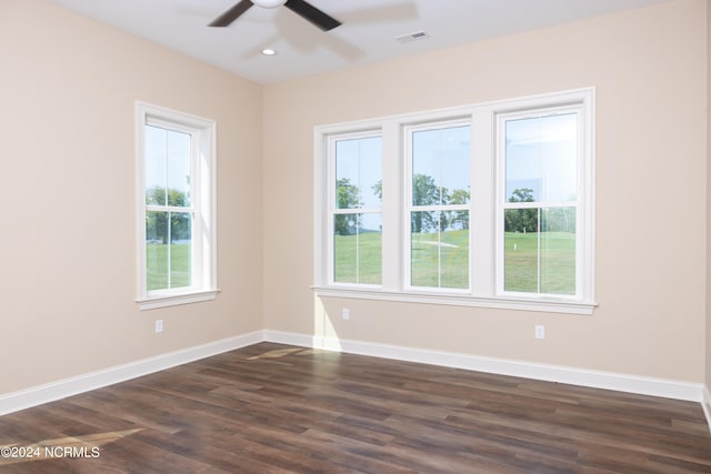 spare room featuring plenty of natural light, ceiling fan, and dark hardwood / wood-style floors