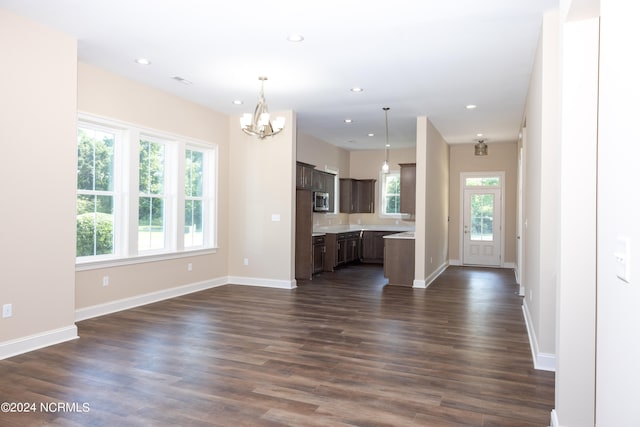 unfurnished living room with dark hardwood / wood-style floors and a chandelier