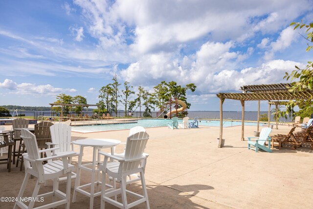 view of patio featuring a community pool and a water view