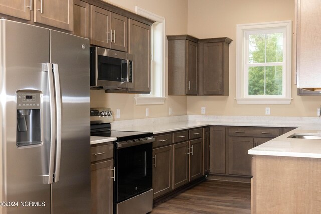 kitchen featuring appliances with stainless steel finishes, dark hardwood / wood-style floors, and dark brown cabinets