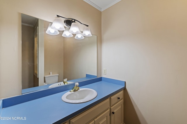 bathroom with ornamental molding, vanity, and toilet