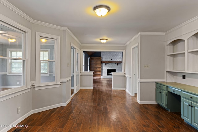 interior space with ornamental molding, green cabinets, dark hardwood / wood-style floors, and a fireplace