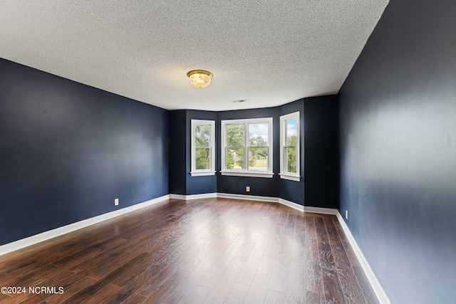 unfurnished room with a textured ceiling and hardwood / wood-style floors