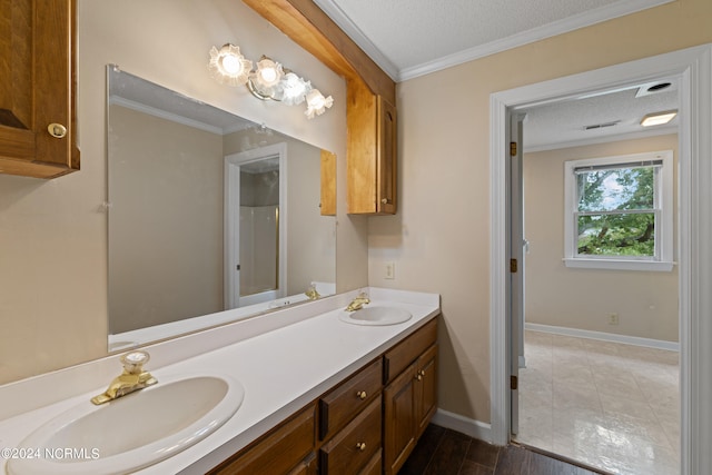 bathroom featuring a textured ceiling, crown molding, vanity, and wood-type flooring