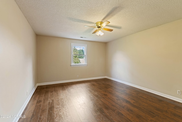 empty room with ceiling fan, dark wood-type flooring, and a textured ceiling