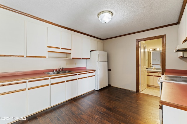 kitchen with a textured ceiling, white refrigerator, dark hardwood / wood-style floors, sink, and white cabinetry