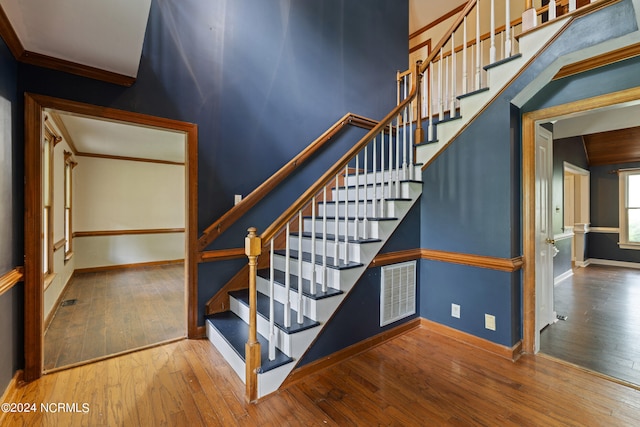 stairs featuring ornamental molding and hardwood / wood-style floors