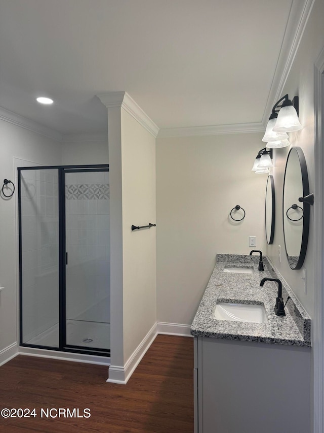 bathroom featuring vanity, crown molding, hardwood / wood-style flooring, and a shower with door