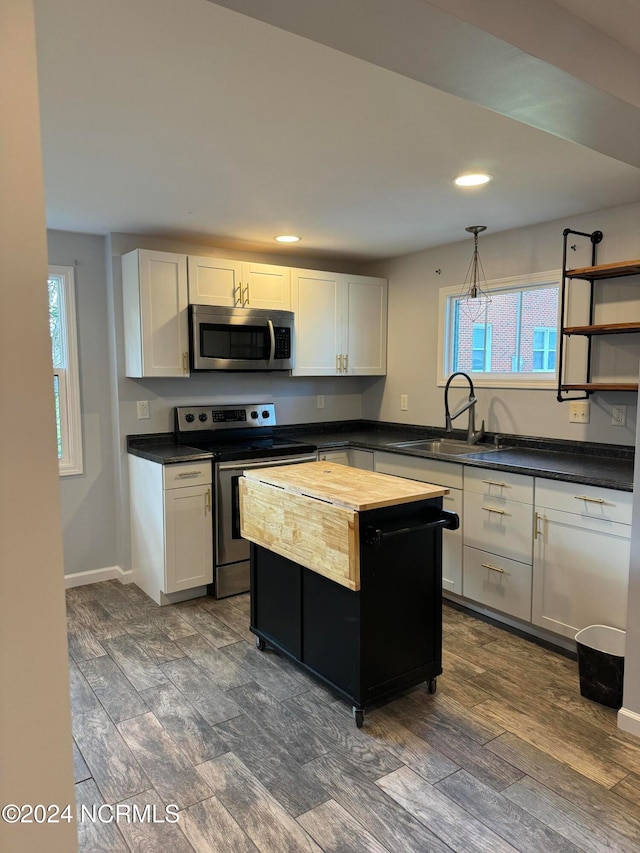 kitchen with wooden counters, stainless steel appliances, sink, white cabinets, and dark hardwood / wood-style flooring