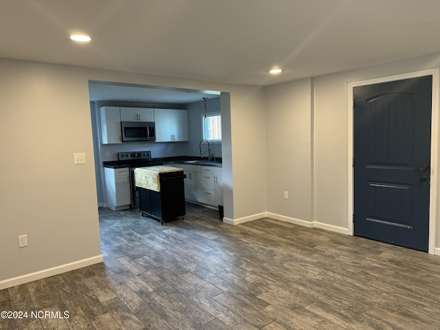 403 Main St, Bayboro, NC 28515 - kitchen with stainless steel appliances, a sink, dark countertops, dark wood-type flooring, and recessed lighting