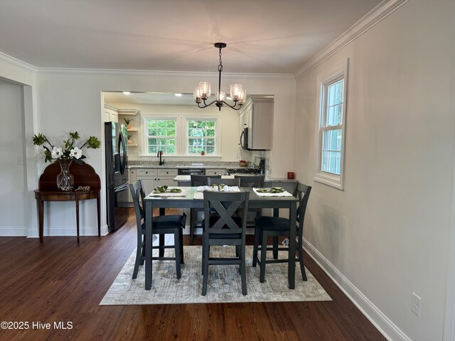 403 Main St, Bayboro, NC 28515 - dining space with a chandelier, dark wood-style flooring, baseboards, and crown molding