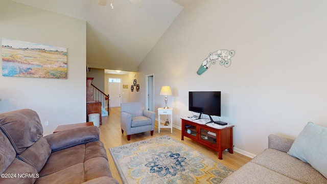 living room with ceiling fan, high vaulted ceiling, and light wood-type flooring