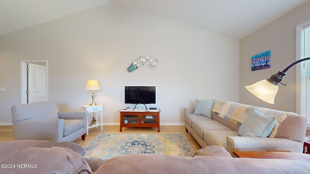 living room featuring high vaulted ceiling and light hardwood / wood-style floors