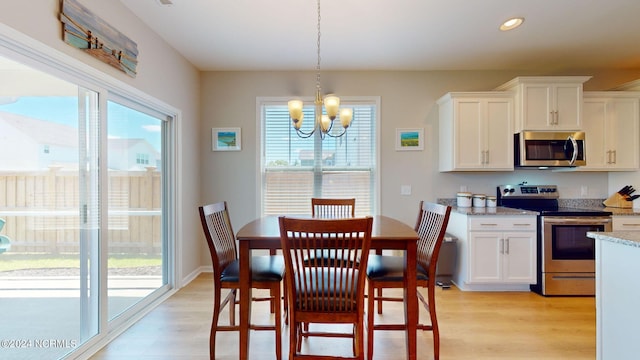 dining area with a notable chandelier and light wood-type flooring