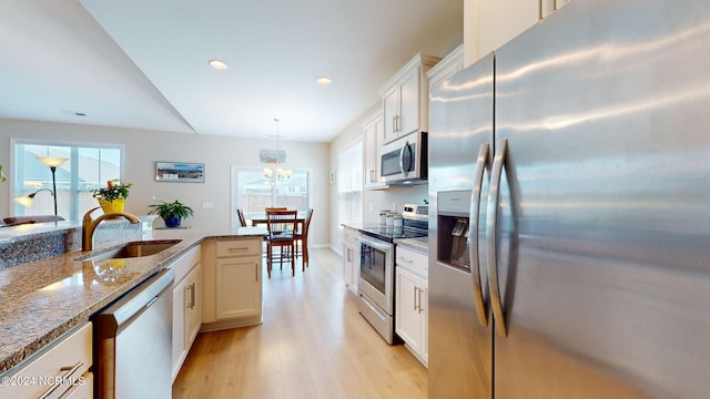 kitchen featuring pendant lighting, sink, white cabinets, and appliances with stainless steel finishes