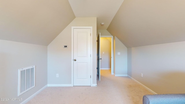 bonus room featuring vaulted ceiling and light colored carpet