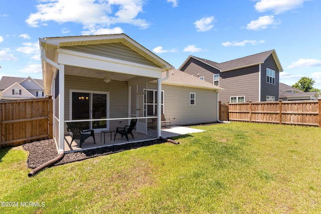 rear view of property with ceiling fan, a yard, and a patio