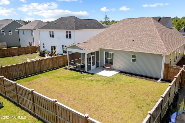 back of house with a yard, a sunroom, and a patio area