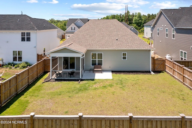 back of house featuring a patio area and a lawn