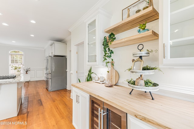 kitchen with white cabinets, wine cooler, wooden counters, stainless steel appliances, and light wood-type flooring