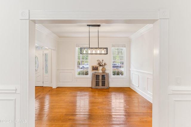 unfurnished dining area with crown molding and hardwood / wood-style floors