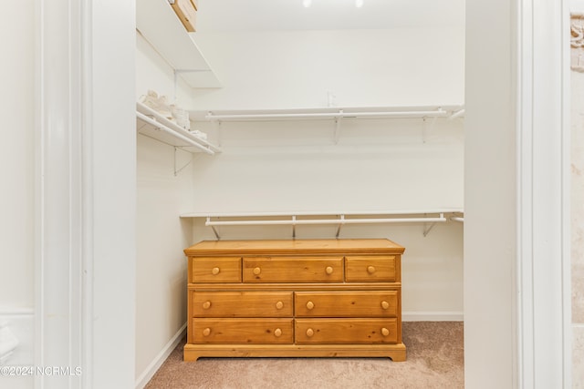 walk in closet featuring light colored carpet