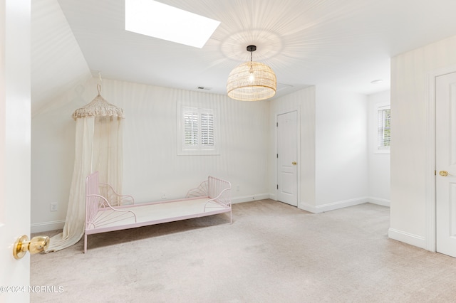 unfurnished room with light carpet, a notable chandelier, and lofted ceiling with skylight