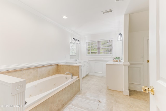 bathroom with ornamental molding, tiled tub, vanity, and tile patterned flooring