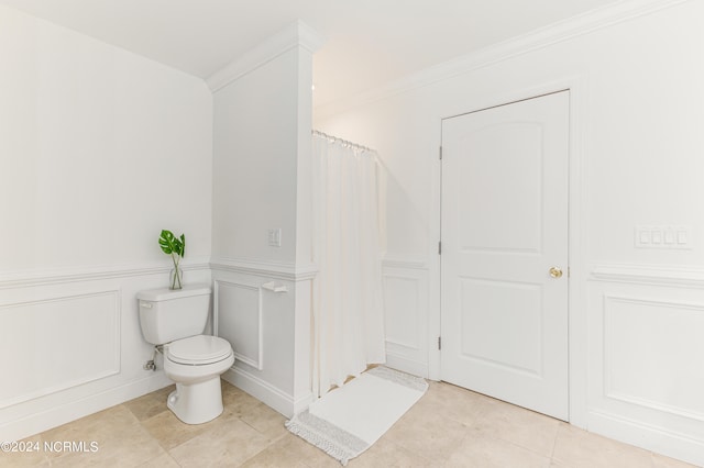 bathroom featuring tile patterned flooring, walk in shower, crown molding, and toilet