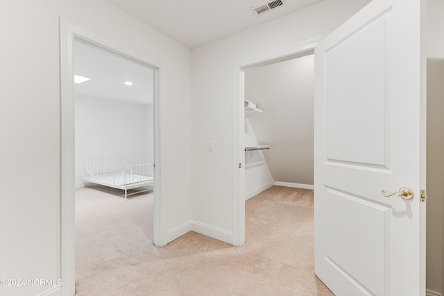 spacious closet featuring light colored carpet