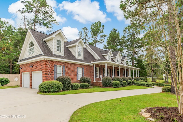 cape cod-style house featuring a garage, a porch, and a front lawn