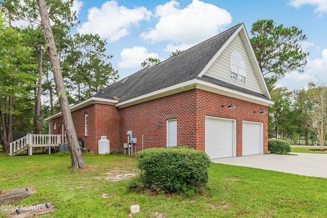 view of side of home with a lawn and a garage