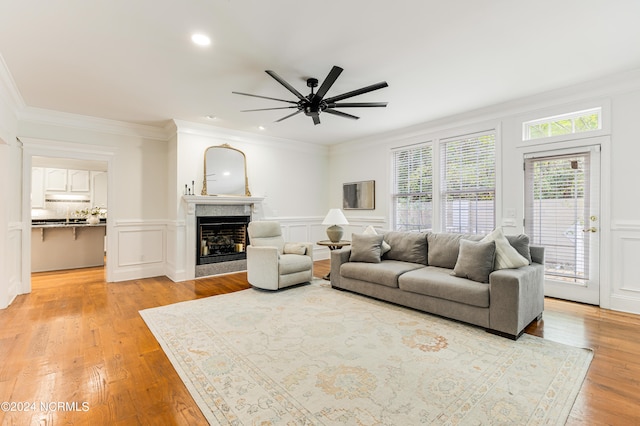 living room featuring ornamental molding, ceiling fan, and light hardwood / wood-style flooring