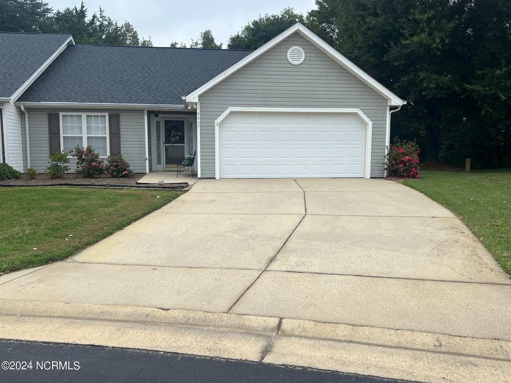 view of front of property with a garage and a front yard