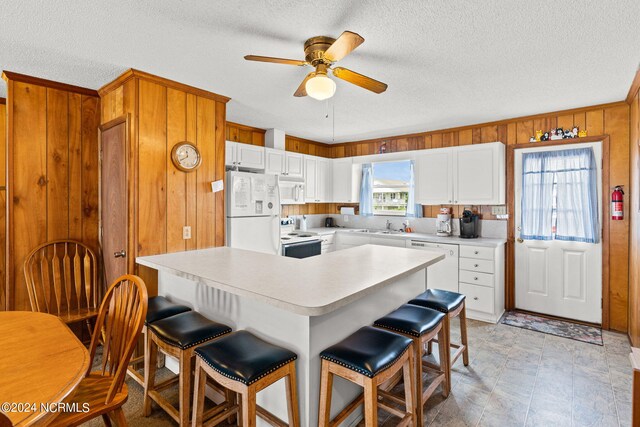 kitchen with ceiling fan, white cabinets, a textured ceiling, and white appliances