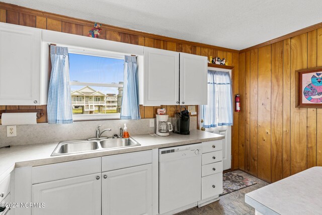 kitchen featuring dishwasher, sink, white cabinetry, and a healthy amount of sunlight