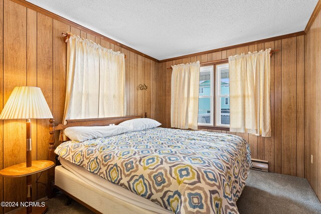 carpeted bedroom featuring crown molding, a baseboard radiator, wood walls, and a textured ceiling