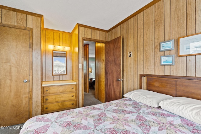 bedroom featuring crown molding, carpet, wood walls, and a closet