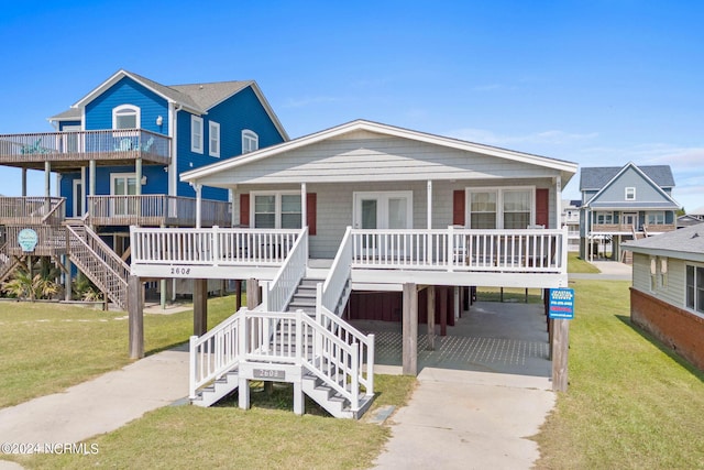 beach home with a front lawn, a carport, and a porch