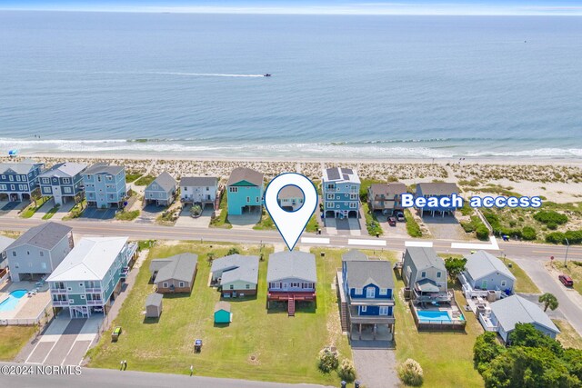 birds eye view of property with a water view and a beach view