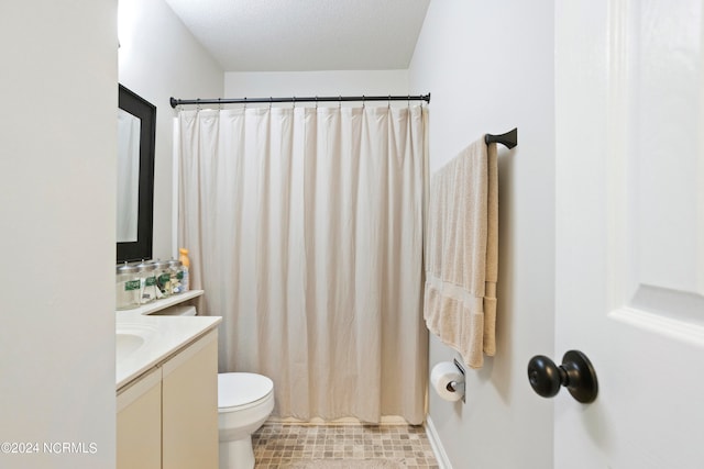 bathroom with a textured ceiling, vanity, toilet, and walk in shower