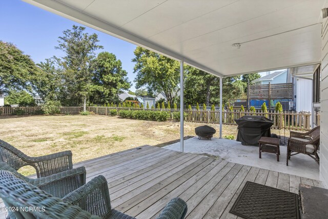 wooden deck featuring a lawn and grilling area