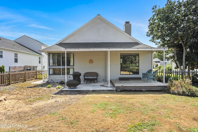 rear view of property featuring a lawn, a patio, and a deck