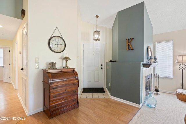 foyer entrance featuring plenty of natural light, vaulted ceiling, and hardwood / wood-style flooring