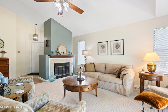 living room featuring lofted ceiling, light colored carpet, ceiling fan, and a tiled fireplace