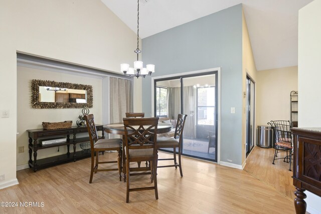 dining space featuring a notable chandelier, high vaulted ceiling, and light hardwood / wood-style floors