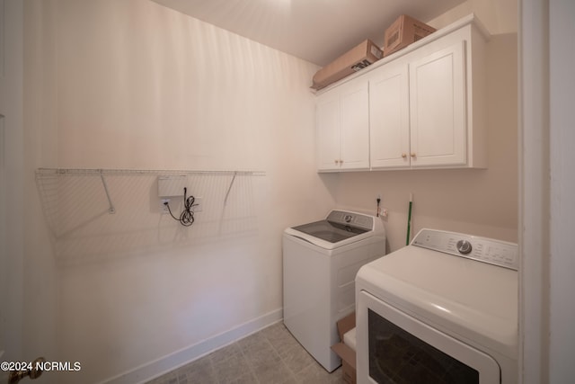 laundry room with cabinet space, baseboards, and separate washer and dryer